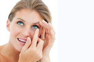 Woman blonde putting in contact lens